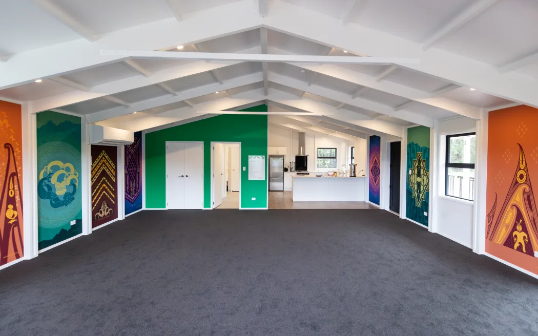 Whare manaaki interior - Tuakiritanga identity wall artworks lining the side walls