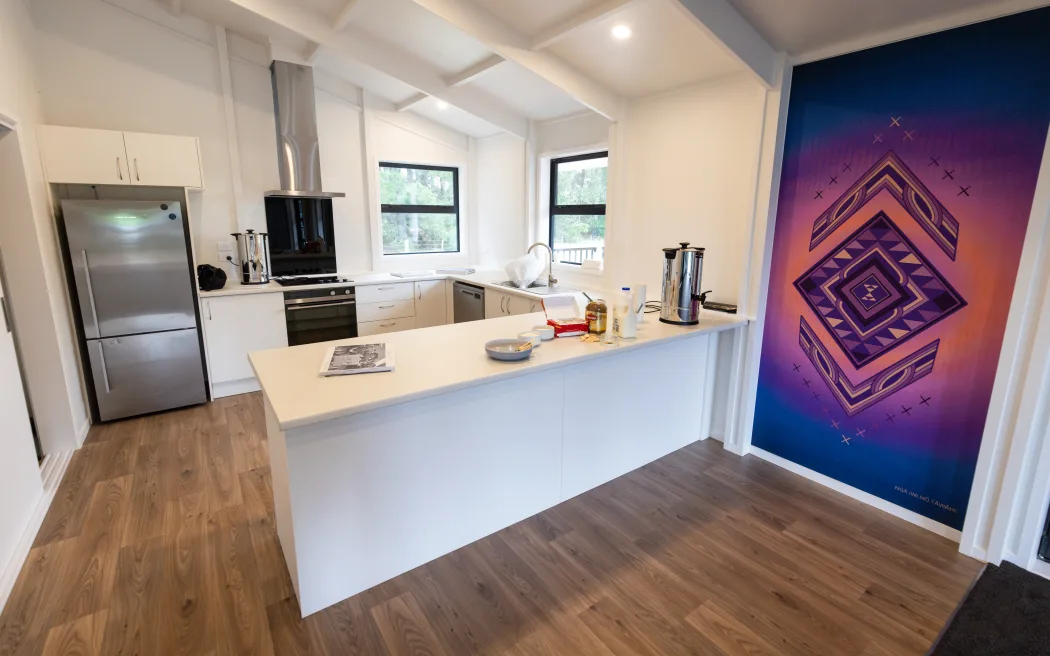 Kitchen and Kia Tipu, Kia Ora te Rangatahi artwork inside the whare manaaki